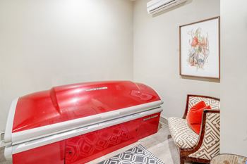The spa has a red jetted tub in the corner of the room